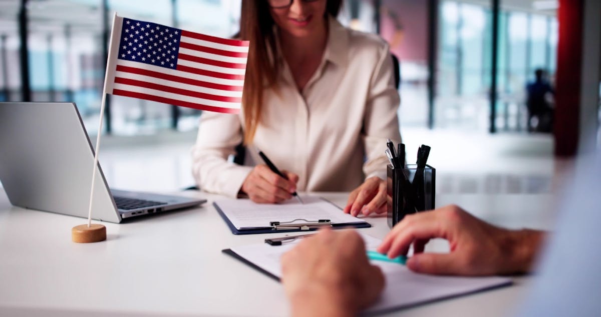 Immigration attorney reviewing paperwork at desk with American flag